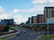 The start of the Sheffield Parkway, as viewed from Park Square, where it meets the City Centre. The road, in the centre, is six lanes wide and leads towards the Parkway Edge development (left-centre) where the road meets the Inner Ring Road. To the left is the Sheffield Supertram viaduct and beyond that a new apartment complex.