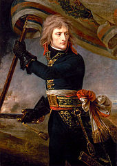 Three-quarter length depiction of Bonaparte, with black tunic and leather gloves, holding a standard and sword, turning backwards to look at his troops
