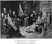 A print showing sixteen people in a large room with paintings and a large bookcase against the wall. A man with long white hair plays a grand piano as several others look on. Wagner, wearing a cap and leaning on the arm of a chair, follows the music in a score.