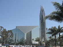 The Crystal Cathedral is a built in a modern style with panels of glass set in metal frames making both the walls and roof. A tall tower of the same materials rises beside it