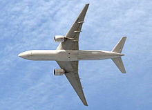 Aircraft in flight, underside view. The jet's two wings have one engine each. The rounded nose leads to a straight body section, which tapers at the tail section with its two rear fins.