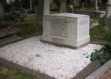 A cubical white marble work of masonry, approximately three feet wide, 18 inches deep and two foot high, inscribed with names of members of the Brunel family, surrounded by marble chippings