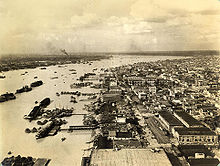 A sepia tone aerial photograph of Calcutta showing the Hooghly river and buildings.