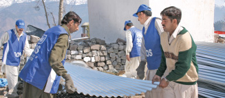 SOS Children volunteers distributing roofing materials