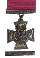 Una cruz paté de oro de bronce que lleva la corona de San Eduardo coronada por un león con la inscripción al Valor. Una cinta carmesí se adjunta