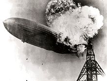 Una fotografía en blanco y negro de una aeronave cerca de una torre de amarre explosión en su popa.