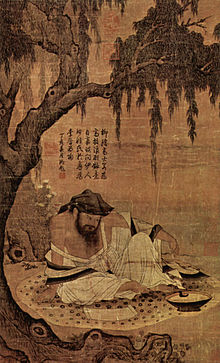 Un retrato de la pintura orientada largo, de un hombre con el torso desnudo, barbudo sentado en una estera debajo de un árbol, leyendo.
