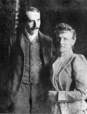 Fotografía del siglo XIX de un hombre de unos 30 años y una mujer de mediana edad de pie al lado del otro. Él tiene un gran bigote, y está mirando a la mujer; ella está mirando directamente a la cámara.