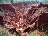 Un vasto, barranco rojo suelo causada por la erosión