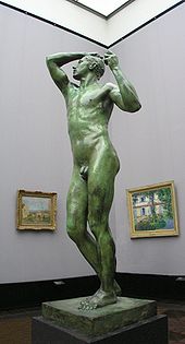 De tamaño real estatura desnudo de un hombre sobre un pedestal en exhibición en un museo.