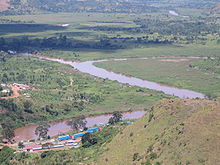 Fotografía de la confluencia de la Kagera y el Ruvubu, con el puesto fronterizo de Ruanda y Tanzania en primer plano, tomada desde una colina cercana