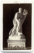 Imagen blanco y negro de una escultura marmor de una mujer haciendo una reverencia con un niño enclavado en el regazo