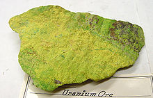 Bloque de piedra de color amarillo-verde con superficie rugosa.