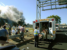 Una víctima herida se carga en una camioneta paramédico con el Pentágono en llamas en el fondo
