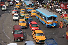 Una carretera congestionada mostrando autobuses, taxis, autorikshaws y otros medios de transporte por carretera