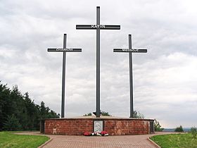 Un monumento que consta de tres cruces de pie sobre un pedestal de ladrillo grande. Cada cruz tiene un nombre - Katyn, Kharkiv, o Miednoje.