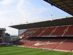 Una tribuna en un estadio deportivo. Los asientos son predominantemente rojo.