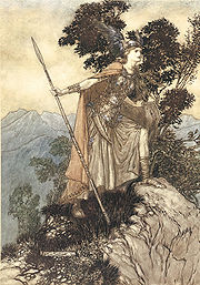 Une valkyrie jeune, portant une armure, manteau et casque ailé et tenant une lance, se tient avec un pied sur un rocher et regarde attentivement vers la droite au premier plan. Dans l'arrière-plan sont les arbres et les montagnes.