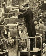 dessin d'un homme d'âge moyen en robe de soirée, vu de sa gauche, d'un orchestre