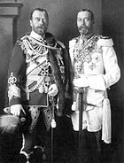 Deux hommes barbus de hauteur identiques portent des uniformes tenue militaire arborant médailles et se tiennent côte à côte