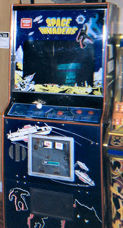 Une borne d'arcade bleu avec un écran entouré de décalcomanies. Les contrôles de jeu sont assis en dessous de l'écran, tandis que la phrase