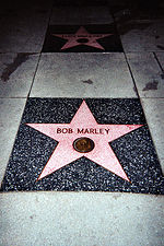 Un cinq étoiles pointue rose incrusté dans le trottoir avec Bob Marley écrit sur elle.