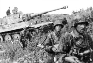 Un char moyen avançant à travers un champ entouré par des soldats allemands.