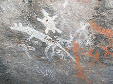 mur de pierre grise avec des dessins primitifs blanc et orange