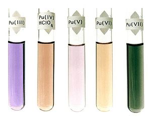 Cinq liuids dans des bouteilles en verre: violet, étiquette Pu (III); brun foncé, l'étiquette Pu (IV) HClO4; violet clair, l'étiquette Pu (V); brun clair, l'étiquette Pu (VI); vert foncé, l'étiquette Pu (VII).