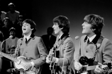 Paul McCartney, George Harrison et John Lennon jouer de la guitare et le port correspondant costumes gris.