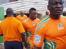 Un gros plan des joueurs Côte d'Ivoire, en maillots oranges de leur pays, entrant dans le champ du tunnel de dressing.