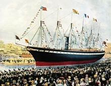 Une foule de gens regardent un grand bateau noir et rouge avec une entonnoir et six mâts ornés de drapeaux