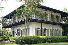 deux étages maison carrée avec de grandes fenêtres et volets extérieurs et un second porche d'histoire