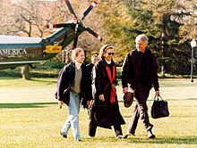 Man, même femme et adolescente marchent à travers la pelouse après avoir quitté un hélicoptère