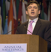 Gordon Brown debout sur un podium. Texte sur les Etats podium