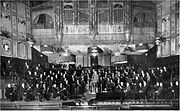 interior de uma sala de concertos vitoriano, que mostra a orquestra e maestro na plataforma