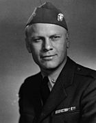 A cabeça e os ombros de um homem em uma Segunda Guerra Mundial-era uniforme da Marinha dos Estados Unidos.