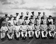 Vinte e oito marinheiros no uniforme da Marinha dos Estados Unidos pose no convés de um Segunda Guerra Mundial-era porta-aviões.