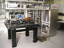 A mesa de laboratório com alguns dispositivos ópticos nele.