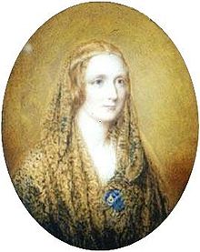 Retrato Oval de uma mulher vestindo um xale e um aro fino ao redor de sua cabeça. Ele é pintado em um fundo de linho colorido.