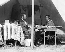 Photograph of Lincoln and McClellan sitting at a table in a field tent