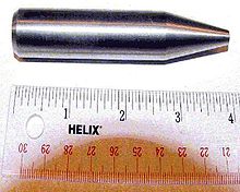 Cilindro metálico brilhante com uma ponta afiada. O comprimento total é de 9 cm e diâmetro de cerca de 2 cm.
