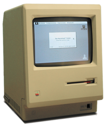 Um computador bege, quadradão com um pequeno ecrã a preto e branco que mostra uma janela e de desktop com ícones.