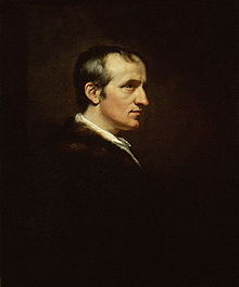 Half-length retrato do perfil de um homem. Sua roupa escura combina com o fundo branco e seu rosto está em contraste gritante.