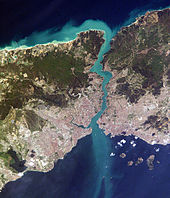 Imagem de satélite mostrando um pequeno pedaço de terra, densamente povoada no sul, cortada por uma via navegável