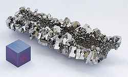 Um nódulo de cristais brilhantes cinza com talhar hexagonal