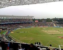 View of a grassy cricket pitch from the stands