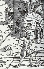 Homem com longa thingie stick-ladel, voltando-se para uma cúpula, quente, forno de tijolos thingie com comportas que vem de fora