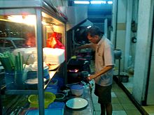 A cook making Char Kuey Teow, a type of flat noodles fried with fish cakes, cockles and bean sprouts.