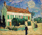 A white two story house at twilight, with 2 cypress trees on one end, and smaller green trees all around the house, with a yellow fence surrounding it. Two women are entering through the gate in the fence; while a woman in black walks on by going towards the left. In the sky, there is a bright star with a large intense yellow halo around it